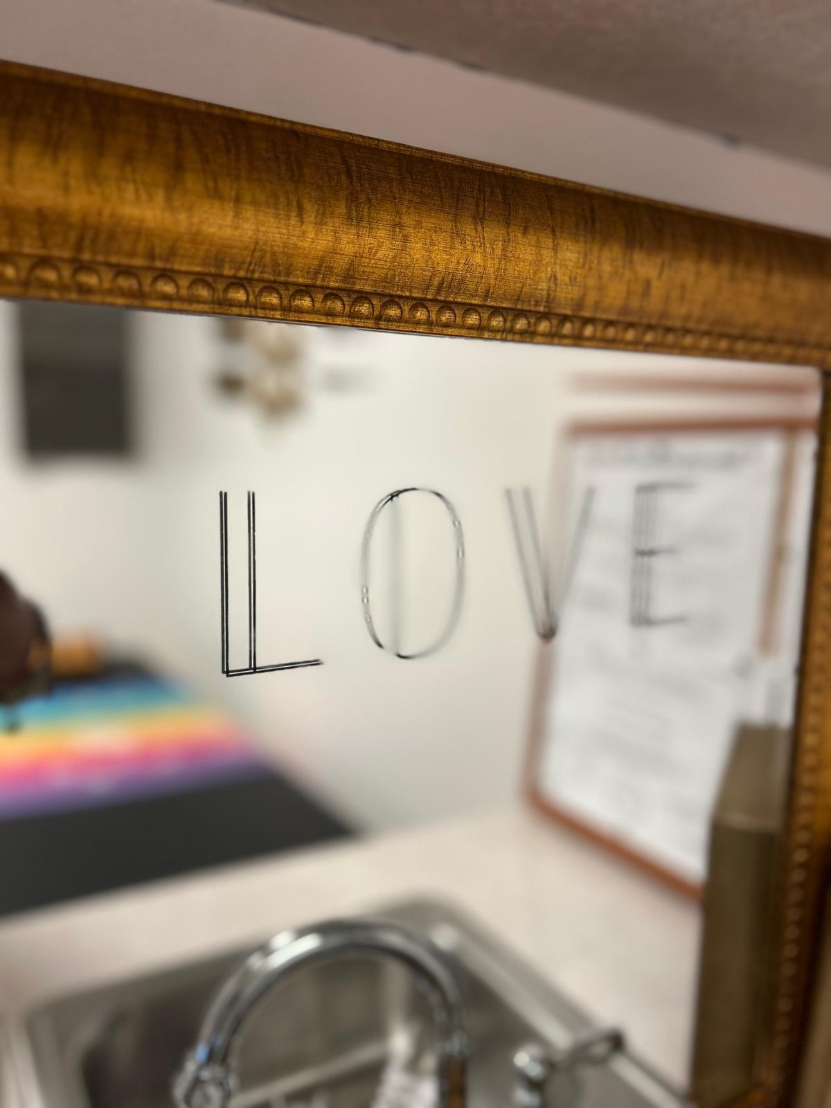 Sacred space with LOVE reflection in ornate mirror, representing the crown, sound, and soul philosophy of Zemi Locs
